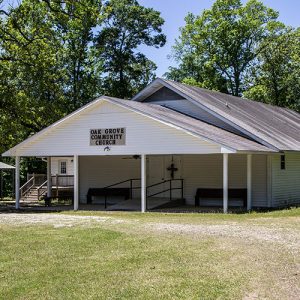 Single-story church building with white siding and covered porch