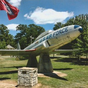 "U.S. Air Force" plane displayed on pedestals with flag pole in park