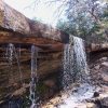 Natural spillway with water pouring over flat rocks