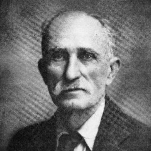 Old white man with mustache in suit and tie