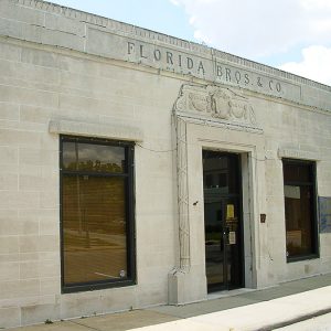 Single-story brick building with Fed-Ex box on street