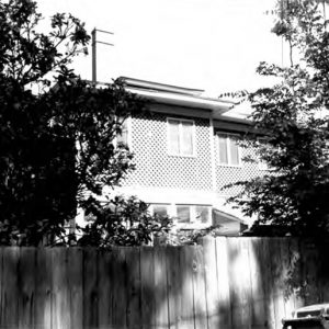 Side view of multistory house with privacy fence