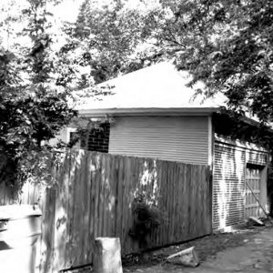 Single-story garage building with privacy fence