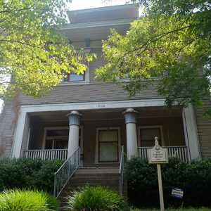 Close-up of multistory house with covered porch and sign