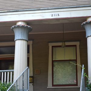 Close-up of covered porch with columns and framed windows