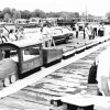 people admiring and working on train-shaped cake on display outside