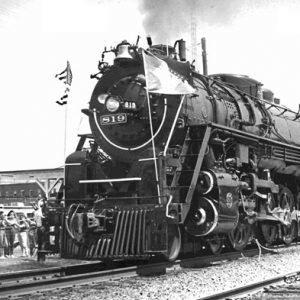 train on tracks, with plume of steam from the engine, spectators on far side of train