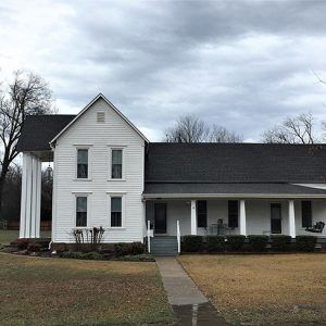 Side view of two-story house with covered side porch