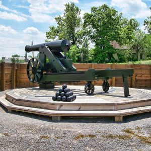 Cannon on platform with cannon balls and wooden retaining wall