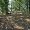 Monument on sloped hill top in forested area