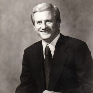 White man smiling in suit and tie