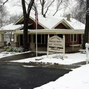 Brick house with American flag and wooden sign "Cleburne County Historical Society"