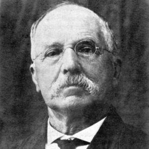 Old white man wearing glasses with mustache in suit and tie