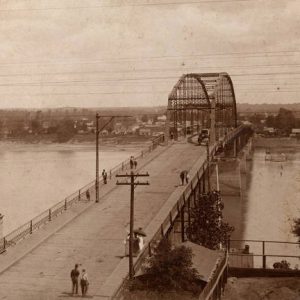 View over concrete highway bridge over river with steel arch