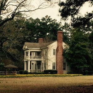 Side view of two-story house with covered porch and balcony