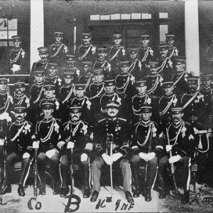 Group photo soldiers on brick building porch hand signed "Fort Logan H Roots 16th INF"