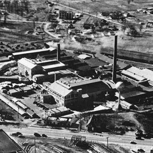 Industrial buildings with smokestacks next to multilane road