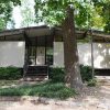 Single-story modern house with recessed entrance and trees in front yard