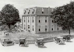 drawing of two story building with people and cars
