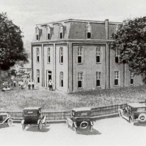 drawing of two story building with people and cars