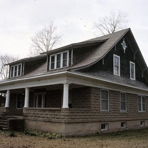 Two-story brown house with covered porch