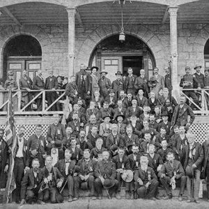 Crowd of white soldiers in suits on steps and porch of stone building