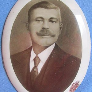 White man with curly mustache in suit and tie