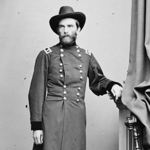 White man with beard standing in military uniform and hat