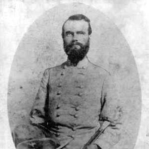 white man with beard in military regalia holding hat and baton