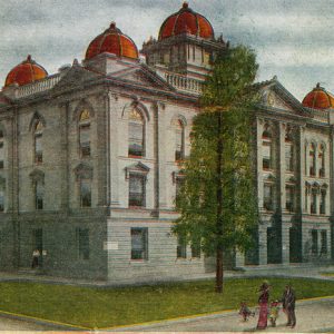 White men woman and children standing outside multiple story building with domes on its roof