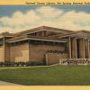 Brick building with flat roofs and covered entrance on post card