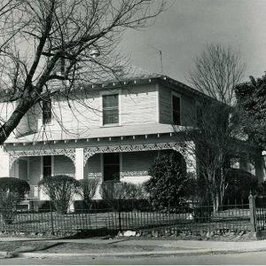 Multistory house with covered porch and fence