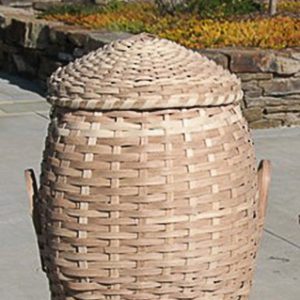 Large basket with lid on brick wall