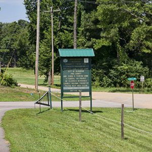 Green park sign and fence at rural intersection