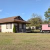 Railroad depot building with wheelchair ramp and red train car