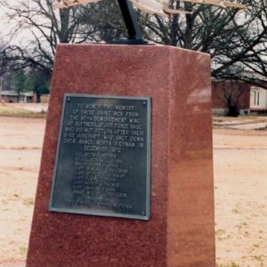 Model airplane attached to red base with a plaque fixed to it