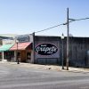 "Enjoy Grapette soda" logo on side of storefront on street