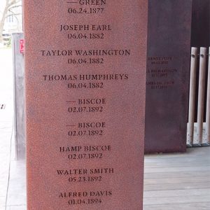 Rust-colored metal rectangle engraved with names and locations