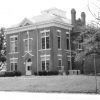 Two-story brick building with trees and grounds