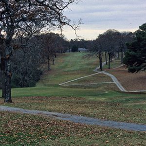 Golf course with overcast skies trees and walking paths