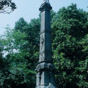 Soldier on top of obelisk shaped monument with pedestal