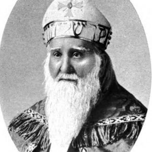 White man with long beard in bishop's robes and miter with cross