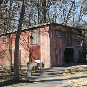 weathered red wooden building with wide arched entrance