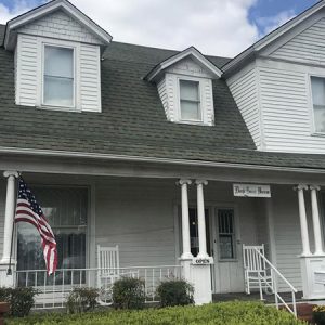 Multistory house with covered porch and American flag