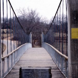 Looking down suspension foot bridge with plaque