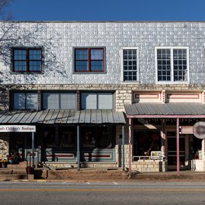 Two story stone building with awnings and sidewalk