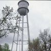 Car and truck parked under water tower