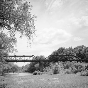 Steel truss bridge with concrete supports over creek