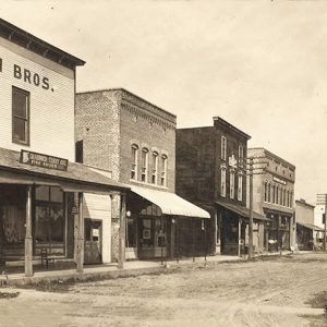 Multistory buildings with covered entrances on dirt street