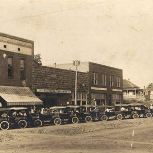 Parked cars on street outside brick store front buildings